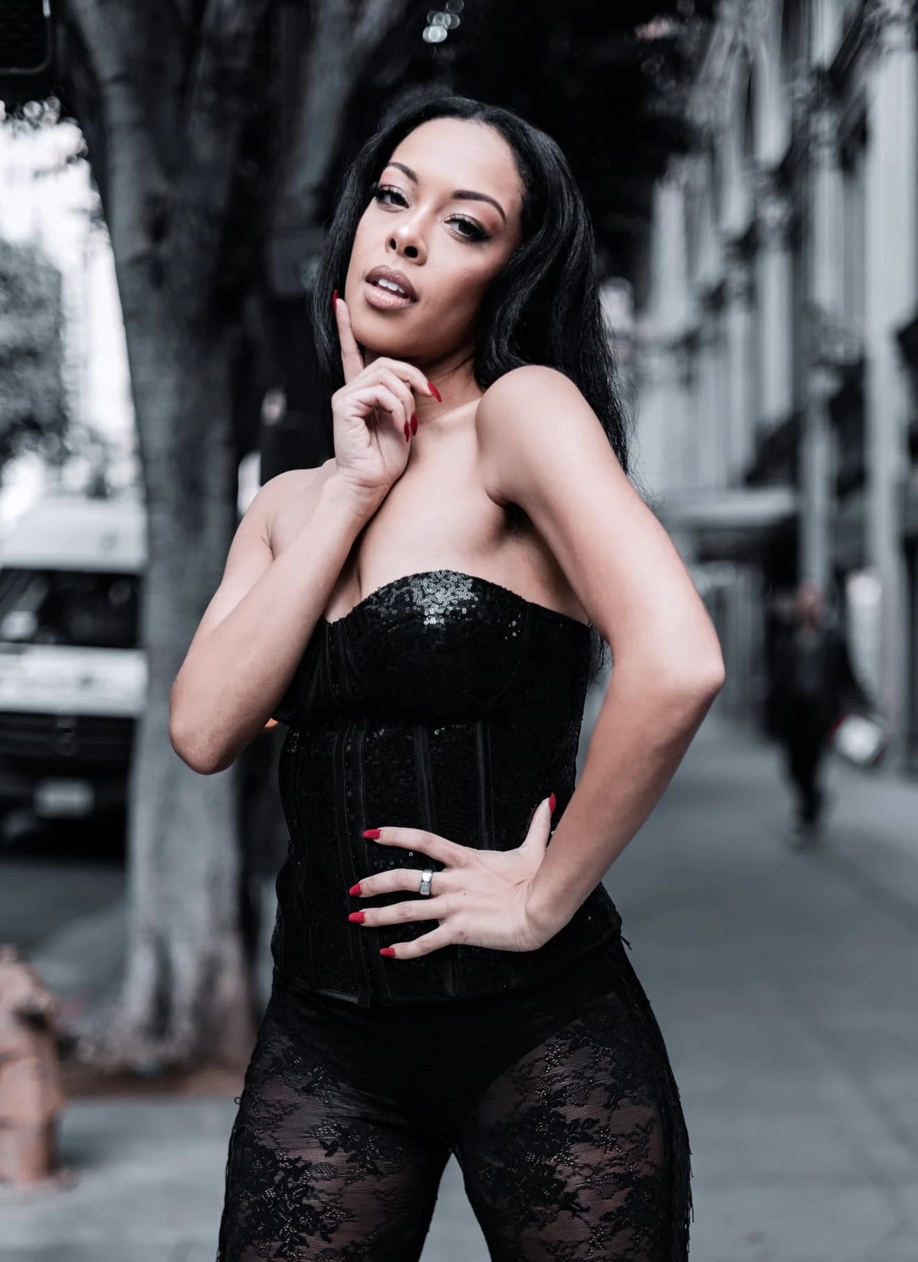 Aliyah Celeste in a black corset outfit on a city street.