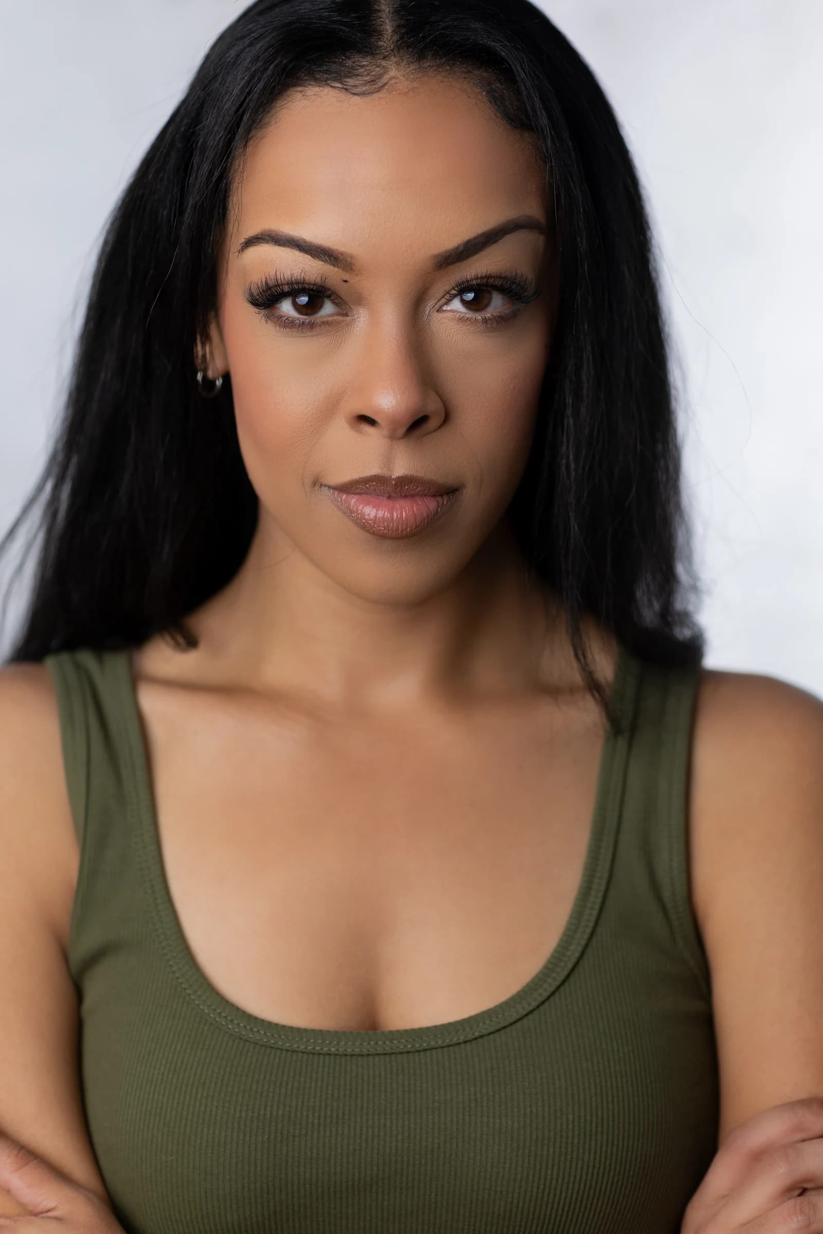 Aliyah Celeste looking directly at the camera in an olive top.